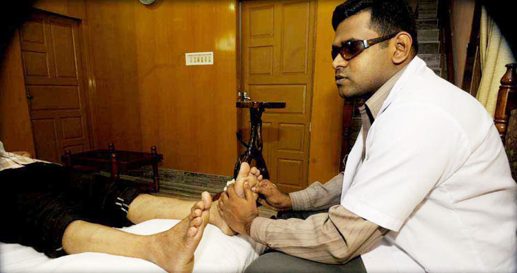 Dr. Ansar consulting patient with Reflexology method